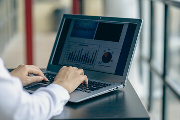 hand of business woman hold smartphone use analyzing and calculating the annual income and...