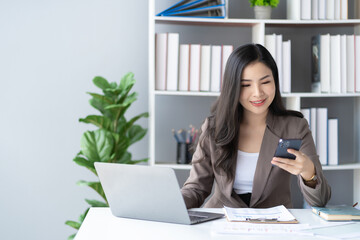 Young Asian businesswoman talking on the phone She is a salesperson at a start-up company. She calls customers to sell products and promotions. financial accounting concept