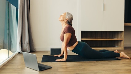 Senior woman practicing yoga in upward facing dog pose