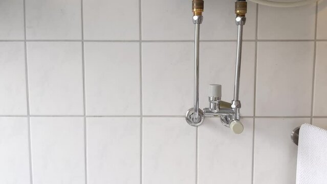 Leaking boiler pipe in modern bathroom