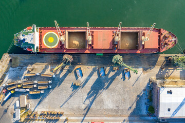 Top view from a drone of a large ship loading grain for export. Water transport