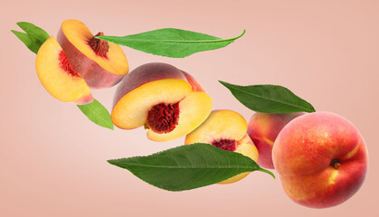 Cut and whole fresh ripe peaches with green leaves falling on pink background