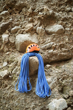 Climbing rope and helmet resting on a rock wall