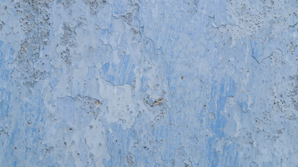 Blue wall of the house. The old wall of the house is painted blue. The old wall of the house is cracked. Background crack in the wall of the house