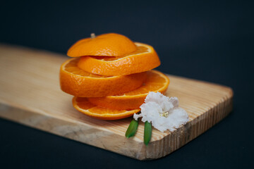 orange cut into round slices close-up on a dark background