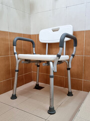 Medical shower chair, the bath seat with padded arms in the hospital restroom