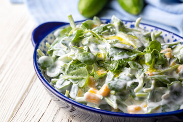 Purslane salad with yogurt in bowl on wooden background.
