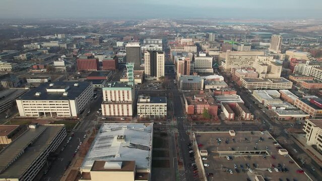 Drone shot and aerial establishing view of office buildings, apartments, and car traffic on streets in downtown capitol Lincoln, Nebraska