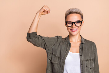 Photo of funny short haircut business lady wear khaki shirt fist up demonstrate her biceps...