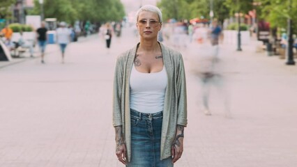 Montage time lapse of different people standing in busy urban street in sunlit city and looking at camera. Modern lifestyle and individuality concept.