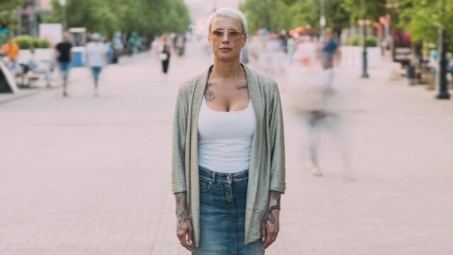 Montage time lapse of different people standing in busy urban street in sunlit city and looking at camera. Modern lifestyle and individuality concept.