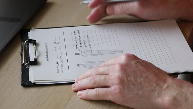 Doctor filling up medical form of the patient