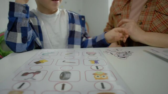 Caucasian autistic preschool boy with a logic teacher. Preparation for school educational games with a professional. High quality 4k footage