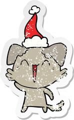 waving little dog hand drawn distressed sticker cartoon of a wearing santa hat