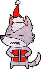 Fototapeta na wymiar hand drawn textured cartoon of a wolf with a gift wearing santa hat