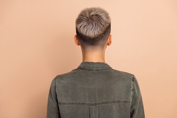 Photo of blond short hair lady dressed khaki shirt standing back isolated beige color background