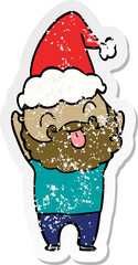 man with beard sticking out tongue wearing santa hat