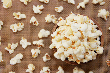 White fried popcorn on a brown background