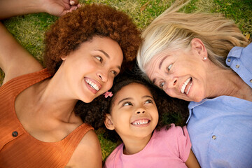 Fototapeta premium Overhead Portrait Shot Of Multi-Generation Female Family Lying On Grass