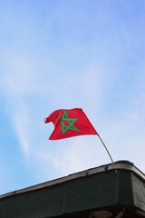 Moroccan Flag Waving with The Blue Cloudy Sky as The Background