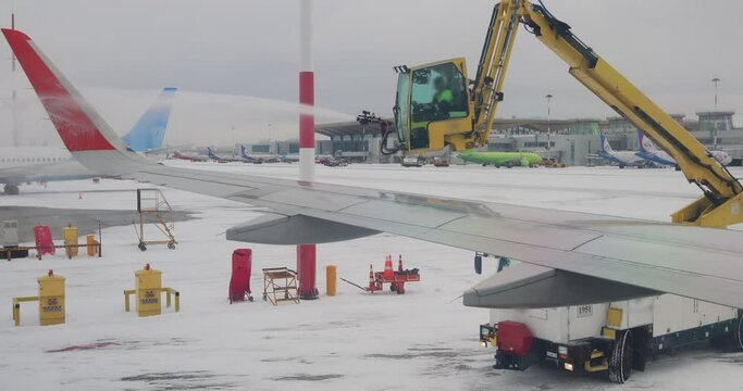 De icing of airplane before flight. Anti-icing is the application of chemicals that not only deice but also remain on a surface and continue to delay the reformation of ice