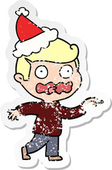 hand drawn distressed sticker cartoon of a stressed out pointing wearing santa hat