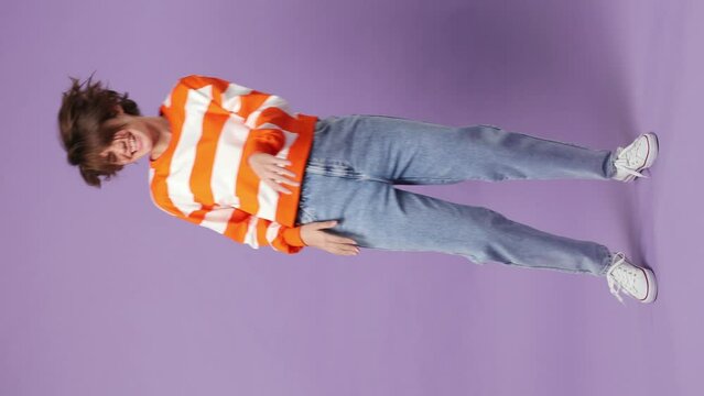 Full body fancy vivid happy bright young woman wear casual clothes dance waving rising have fun enjoy relax celebrate play fluttering hair isolated on plain purple background. People lifestyle concept