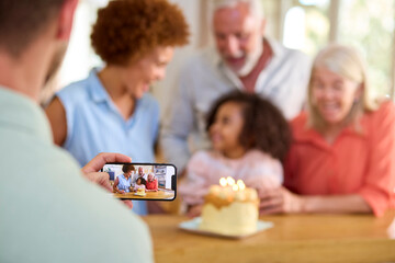 Dad Takes Photo As Multi-Generation Family Celebrate Granddaughter's Birthday At Home With Cake