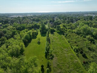 A tranquil landscape of lush green fields, rolling hills and a forest stretching out beneath the...