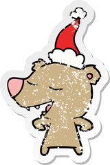 hand drawn distressed sticker cartoon of a bear wearing santa hat