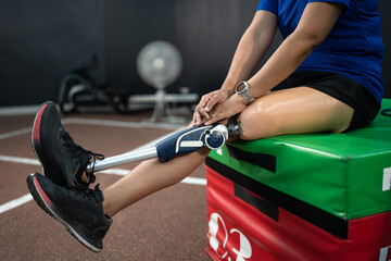 Low angle view at disabled woman with prosthetic leg walking at gym or fitness	