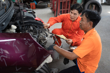 Fototapeta na wymiar Asia mechanic man examining and maintenance to engine a vehicle car hood at car service 