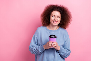 Photo of dreamy pretty woman dressed blue sweatshirt enjoying coffee looking empty space isolated pink color background