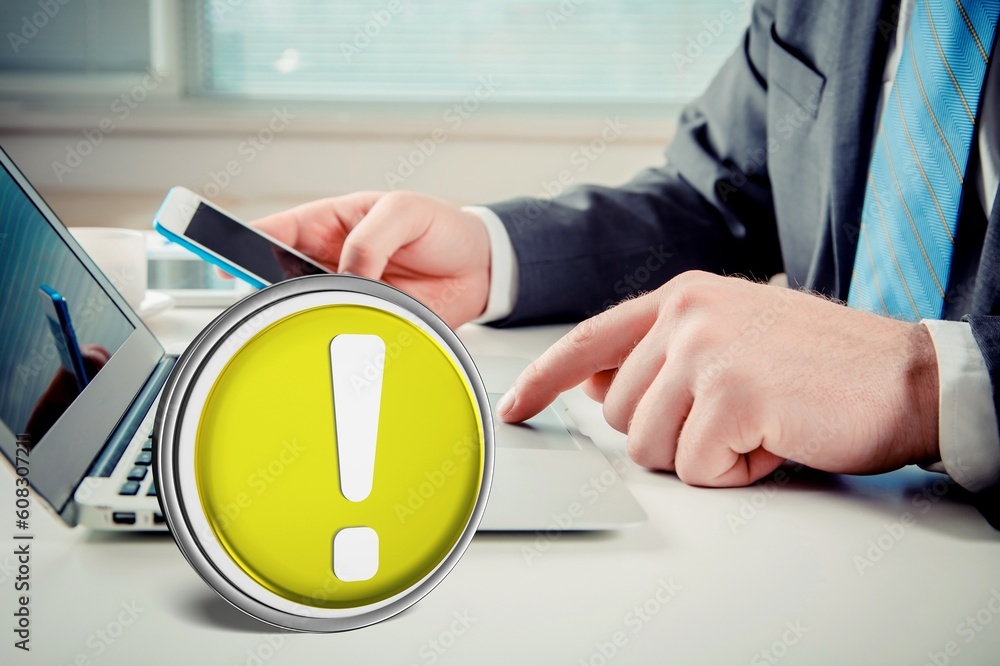 Poster warning yellow sign on table with computer