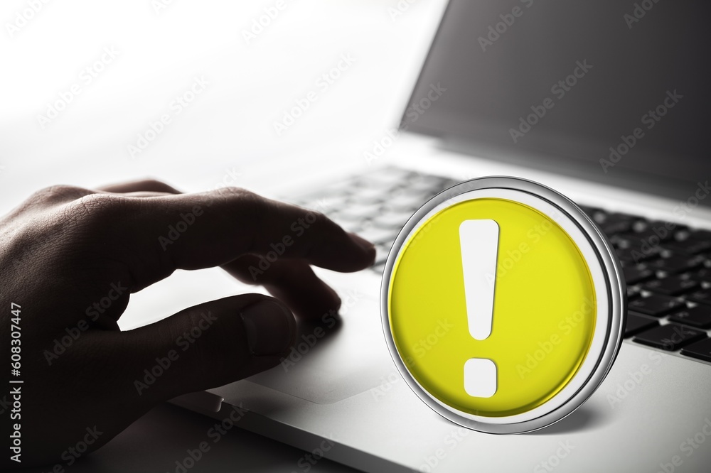 Poster warning yellow sign on table with computer