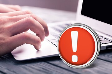 Warning red sign on table with computer