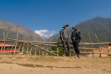 Fototapeta na wymiar A young couple travellers trekking in Poon Hill view point in Ghorepani, Nepal.
