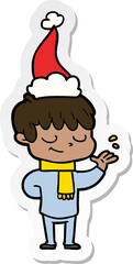 hand drawn sticker cartoon of a happy boy wearing santa hat