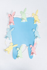 Easter dentistry. Blue tooth and garland of rabbits on a white background, top view