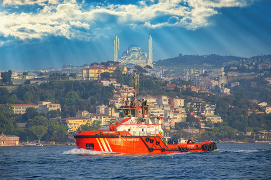 Istanbul, Turkey - May 2022: Coastal safety ship, salvage, search and rescue boat navy coast guard ship in Istanbul Bosphorus. Camlica Mosque urban landscape background.