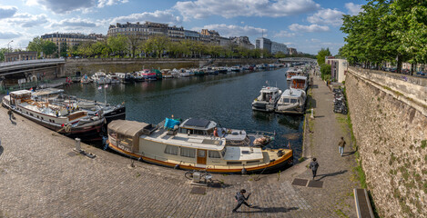 Naklejka na ściany i meble Paris, France - 05 19 2023: Canal Saint-Martin. View of boats in the Dockyard basin .