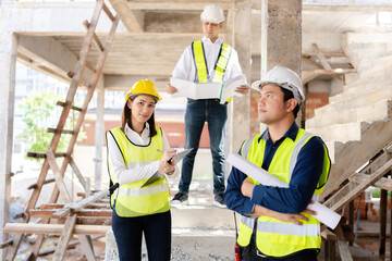 Image of a team of 3 Asian male and female engineers presenting their professionalism In construction design about architecture For industries wearing vests, there are blueprints, radio communications