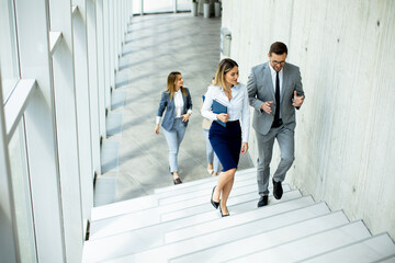 Young startup team have a discussion while climbing on  stairs in the office corridor
