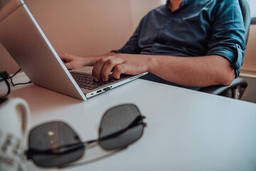 Close-up photo of a programmer typing on a laptop
