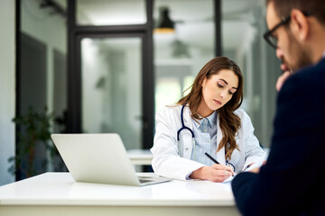 A female doctor writing a prescription to a male patient in the ambulance.