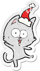 funny hand drawn distressed sticker cartoon of a cat wearing santa hat