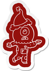 quirky cartoon  sticker of a cyclops alien spaceman pointing wearing santa hat