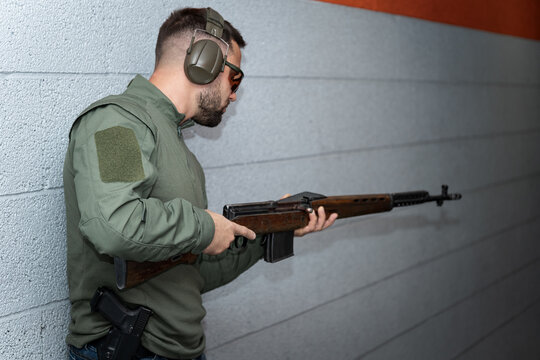 Male shooter with an old svt-40 rifle in a shooting range.