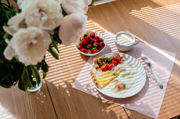 Fried eggs with a slice of pizza and a cup of cappuccino on the table.