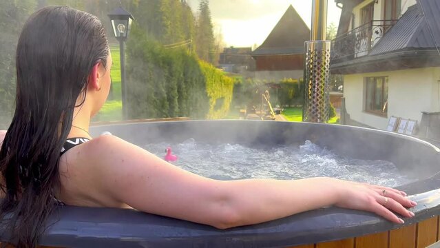 girl bathes in the jacuzzi in the mountains